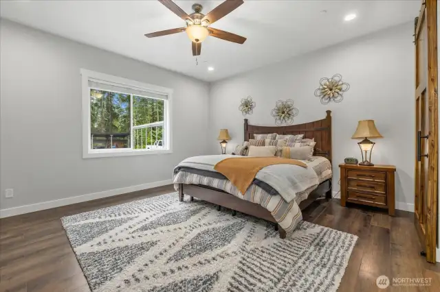 Oversized primary bedroom overlooks peaceful backyard.