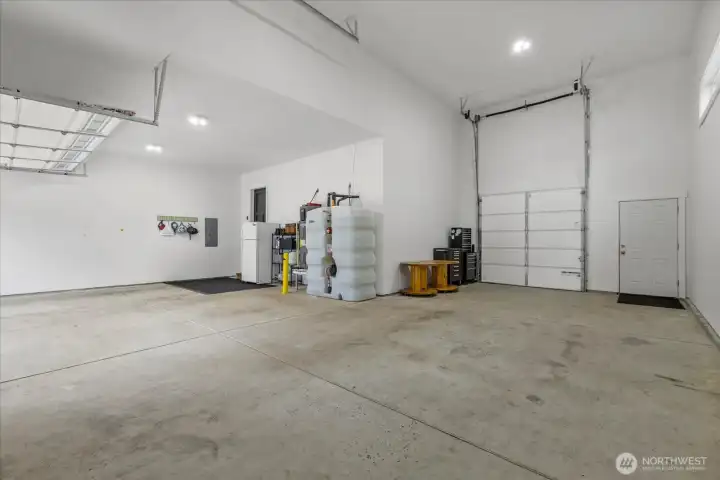 Massive garage features 2 car bay PLUS RV bay with 16' high garage door with 8' wide single garage door leading to back yard.  Room for all your toys with room to navigate through garage or on side.