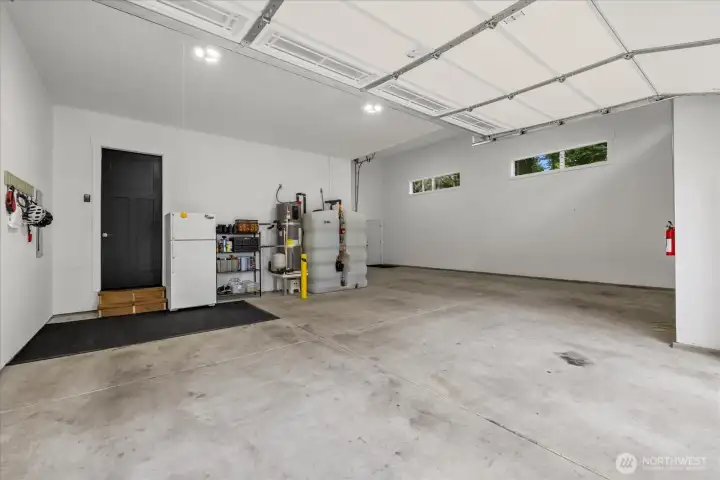 View from 2 car bay. Water heater and fire suppression water tank located here.  Right side is the RV bay with pull through access open to back yard. 200 amp electrical service to the home with generator hook up in the shed out back.