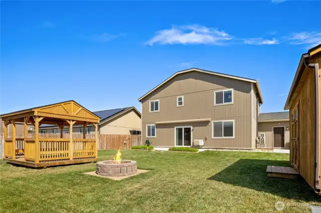 Well designed back yard with a large patio with awning, a gazebo, firepit and storage shed/workshop.  Notice there is a man door into the garage from the back patio!
