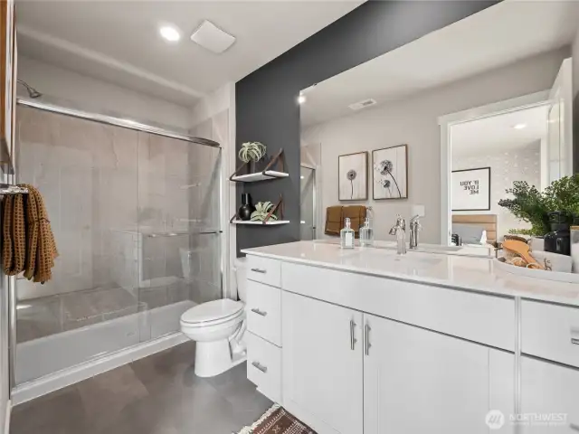 En-suite bath boasts glass-enclosed shower with tile surround, quartz vanity, and sleek fixtures for a spa-inspired finish. Pictures are for representational purposes only, colors and features may vary.