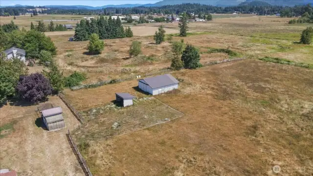 Aerial view of barn, horse shelter and green house.