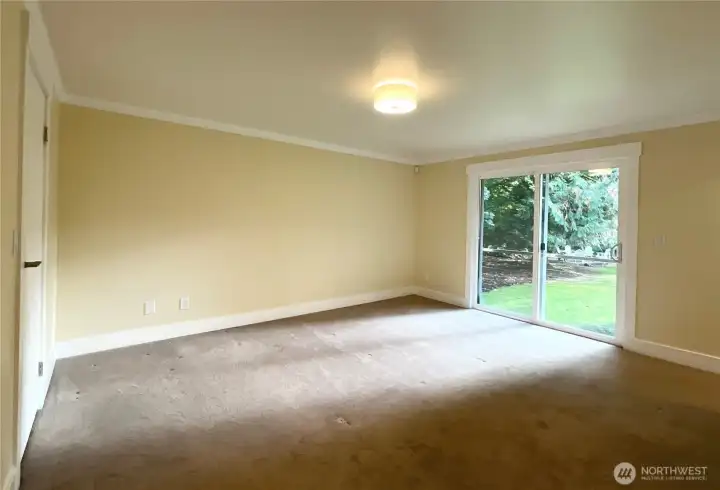 The sliding door to Juliet balcony fills the primary bedroom with natural light.