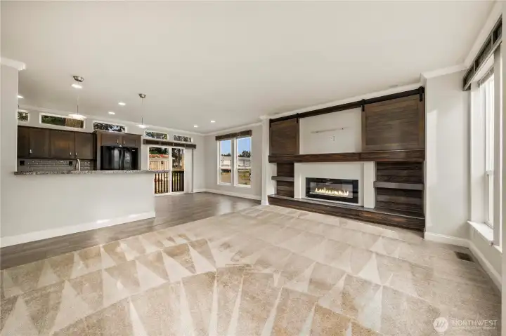 Wide-angle view emphasizes the generous living area and its seamless connection to the kitchen and dining spaces.