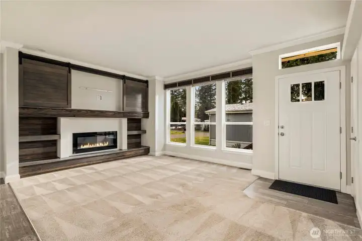 This view highlights the bright entry, energy-efficient double-paned windows, and wood window valances that add warmth and continuity throughout the home.