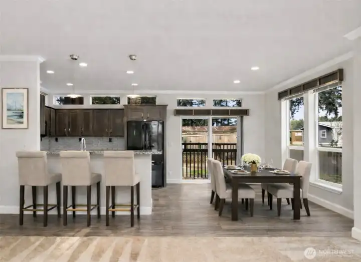 Open dining and kitchen area offers ample space for meals, gatherings, and casual bar seating.  (photo virtually staged)