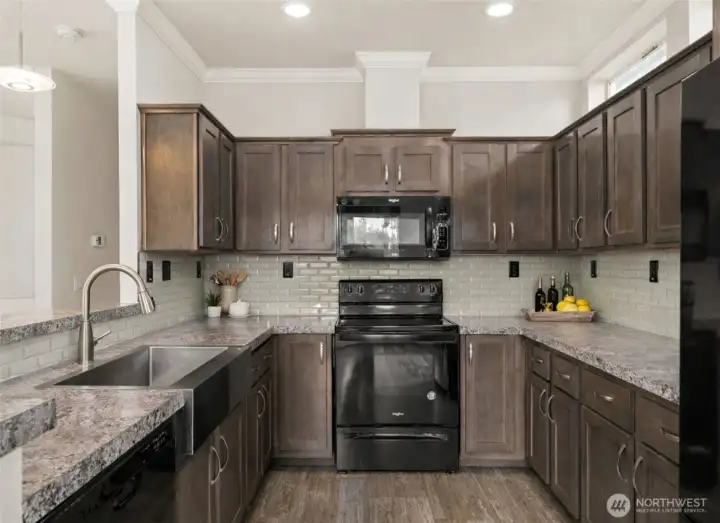 Well-appointed kitchen offers generous counter space, modern appliances, deep SS sink w/gooseneck sprayer and plenty of storage for everyday living. (photo virtually staged w/counter accessories)