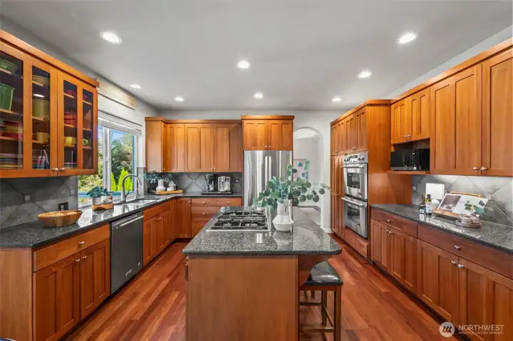 Gourmet kitchen in Horizon West home for sale in North Gig Harbor featuring cherry cabinetry, granite countertops, stainless steel appliances, and Brazilian cherry hardwood floors—an inviting space for cooking and entertaining near Downtown Gig Harbor.
