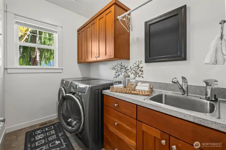 Main floor laundry room in Horizon West home for sale in North Gig Harbor, conveniently located off the garage entry—offering practical workspace, storage, and easy access for everyday living.