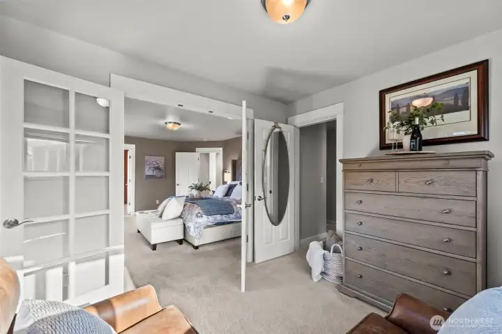 View of primary bedroom from sitting area in Horizon West home for sale in North Gig Harbor, showcasing the generous space, serene atmosphere, and elegant design of this inviting upstairs retreat.