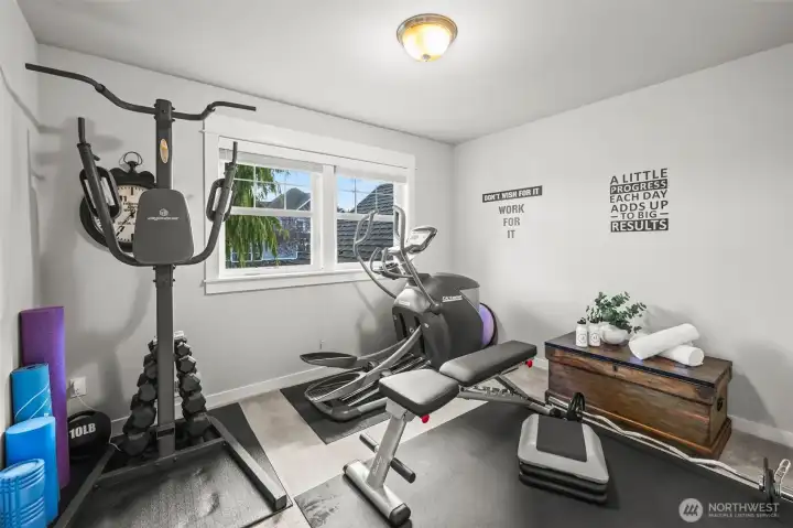 Second bedroom in Horizon West home for sale in North Gig Harbor, currently used as a home gym—versatile space with ample natural light, perfect for fitness, guest room, or hobby area.