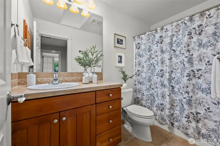 Upstairs full bathroom in Horizon West home for sale in North Gig Harbor featuring a combination tub and shower, extended vanity, and neutral finishes—ideal for guests or family use.
