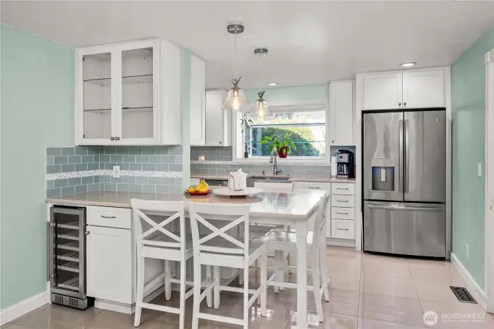 Updated kitchen with breakfast bar, wine fridge and abundant cabinets.