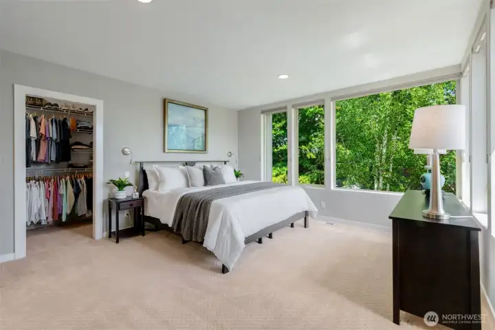 The spacious primary suite boasts corner windows and honeycomb shades The spacious primary suite boasts corner windows and honeycomb shades