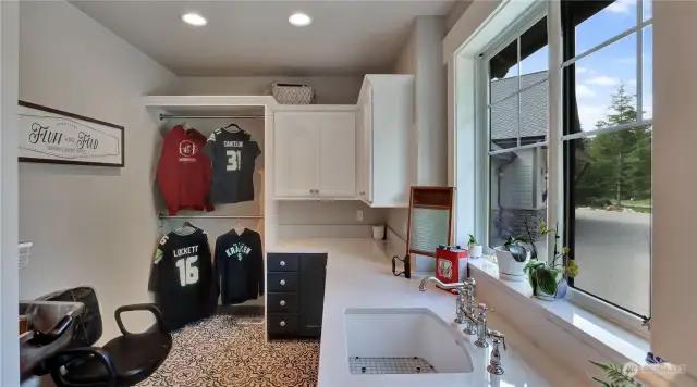 Expansive laundry room with space to hang clothing, ample cabinet space, quartz counters & tons of natural light!