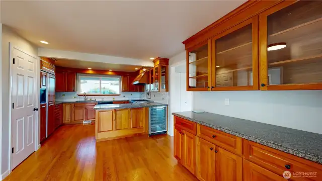 Beautiful gourmet kitchen features hardwood flooring and custom wood cabinetry