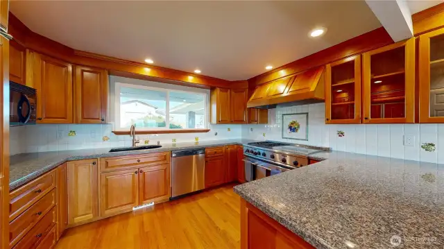 Another view of the kitchen with large window lets in plenty of natural light and an L-shaped counter large island, providing ample workspace for cooking