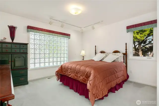 Bright and welcoming secondary bedroom located just off the entry, offering a flexible space for guests, a home office, or a cozy retreat.
