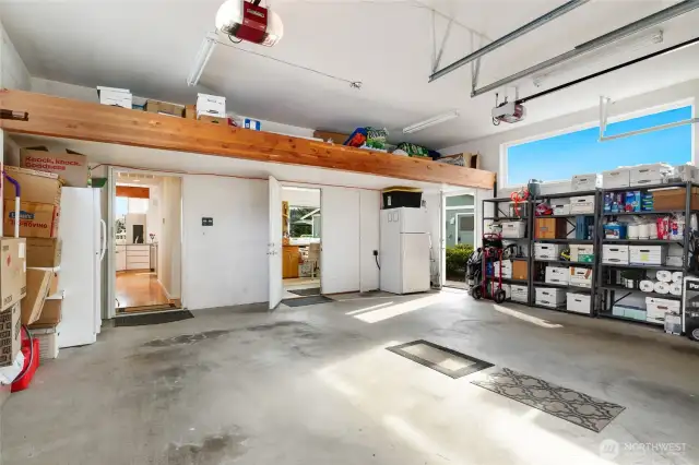 Spacious garage featuring overhead loft storage, providing plenty of room for vehicles and organized storage. Easy access into the kitchen or out the side door for a very short walk to the dock. Enter shop area from garage via the double doors. Freezer and refrigerator/freezer both stay.