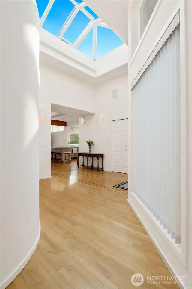Make a grand entrance with this stunning foyer, featuring an oversized skylight that opens electrically, allowing for fresh air and natural light to pour in, creating a bright and airy welcome.