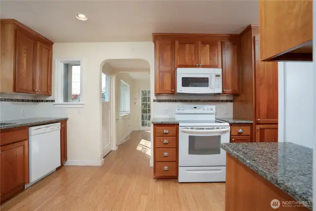 So many cupboards and gleaming granite make kitchen life efficient. The custom cabinets are reminiscent of the original era of the home.  Now let's head through yet another set of arches into the mud room/flex room/laundry area.