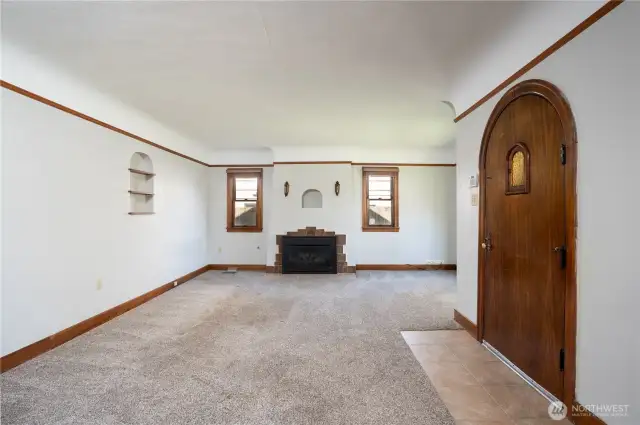 Entering the living room, we have all the fun details one expects from a 1928 home- mahogany wood wrapped windows, door, base mold and picture rail, plus the iconic fireplace (now converted to gas) and don't forget the cute arches.  Not a fan of carpeting?  Fantastic- original hardwoods, in great shape, underneath- rip out the carpet and take this beauty back to her original glory.