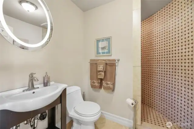 Powder room on main level w/ oversized tiled walk-in shower