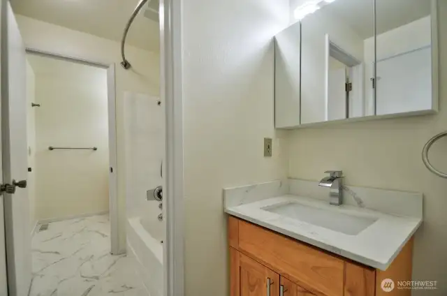 Jack and Jill design bathroom offers a private half bath in primary suite that shares a tub/shower with the hall half bath.