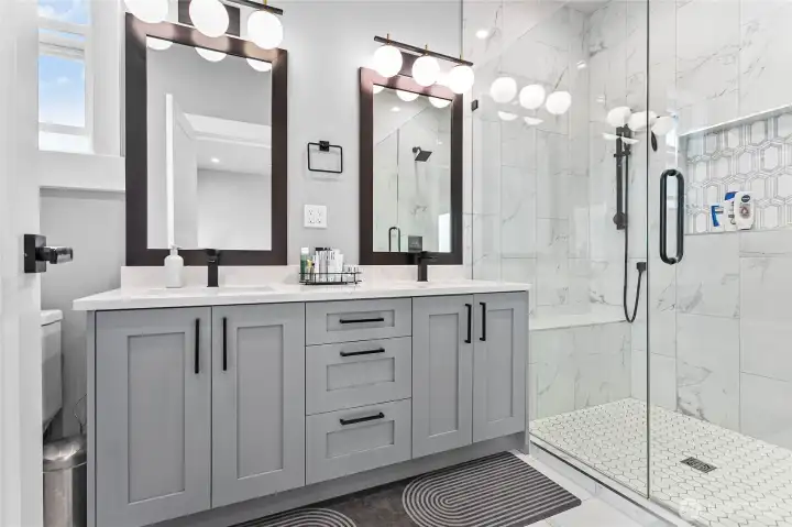 Primary bathroom with double sinks and glass shower door