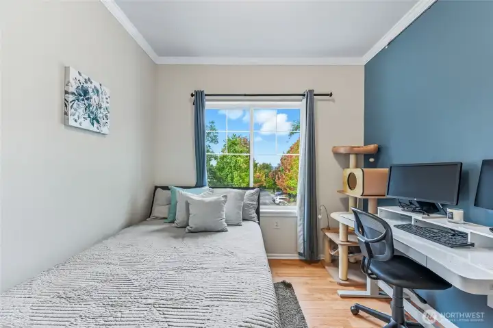 The second bedroom boasts beautiful views of the tree-lined street, creating a serene and inviting atmosphere.