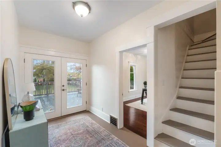 Landing with French doors leads to large entertaining sized deck overlooking private backyard.  Stairs to upstairs bedrooms and bathroom