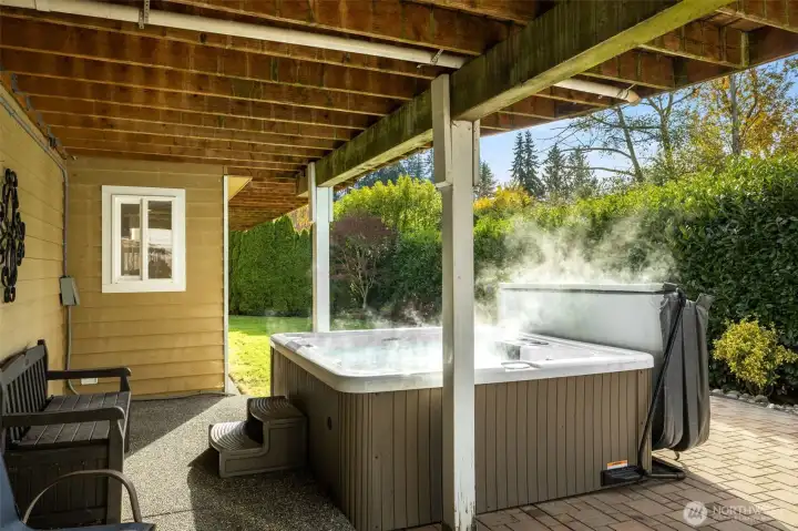 Lower level patio with a hot tub.