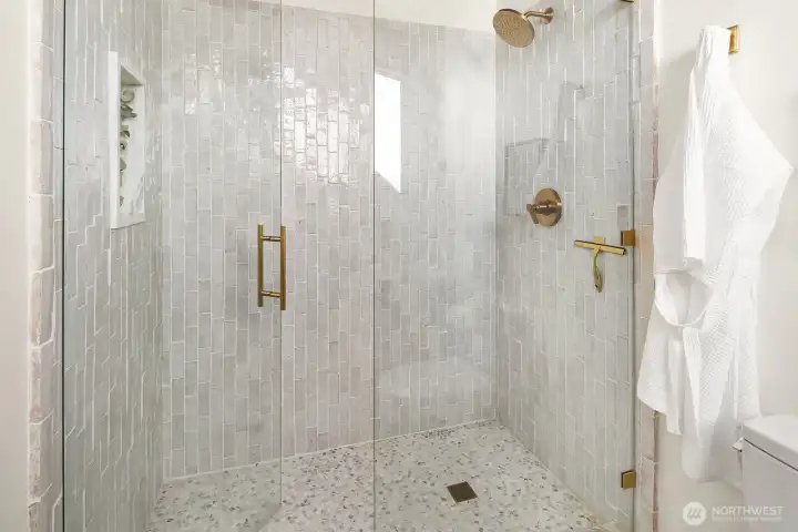 Giant shower with mountain views and marble niche.
