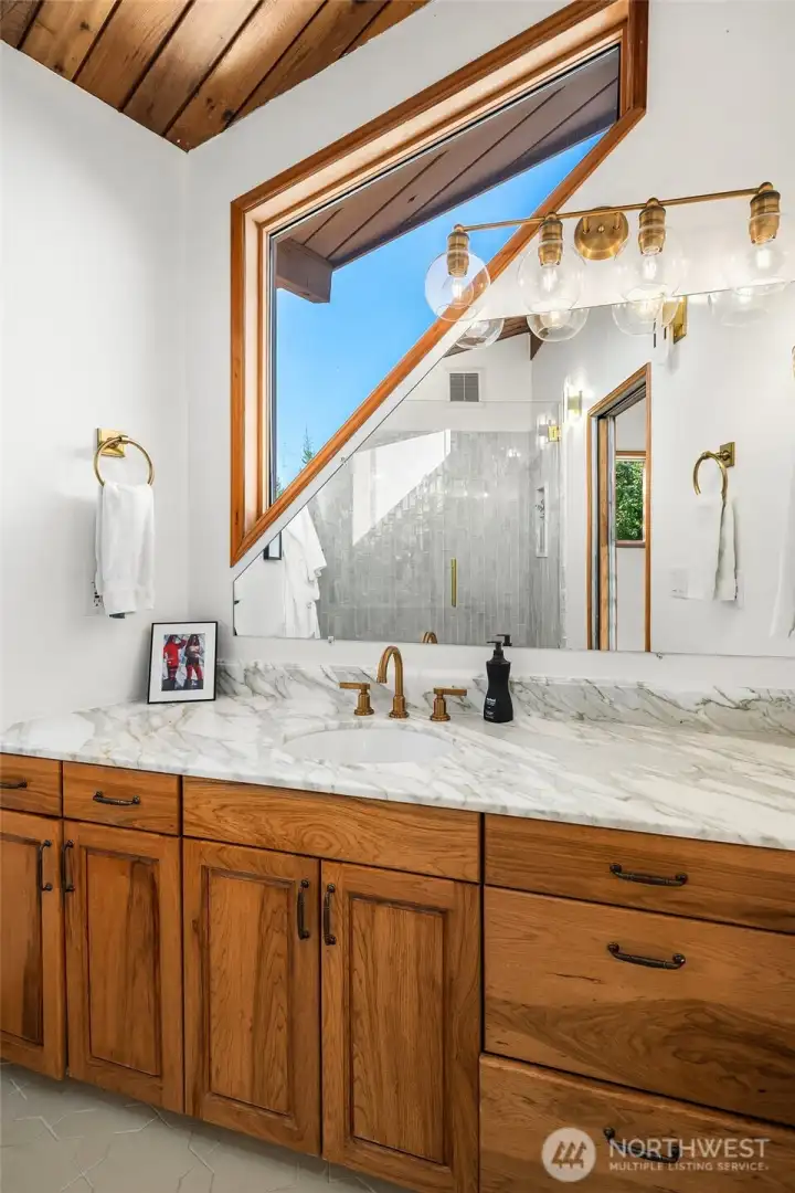 Primary bath with Calcutta counters and Cle' tile flooring.