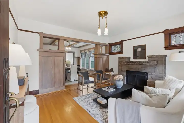 Charm-filled living room with original woodwork, stained-glass windows and wood-burning fireplace