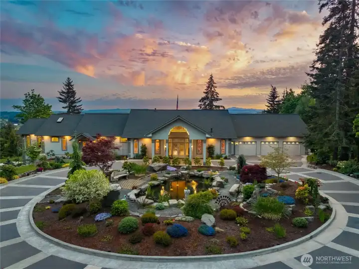 The colors pop with this beautiful landscape job around the koi pond and all framed by the decorative round about driveway that drops you at the front entry under the porte cochere. Driveway is wide enough for two cars to pass comfortably.