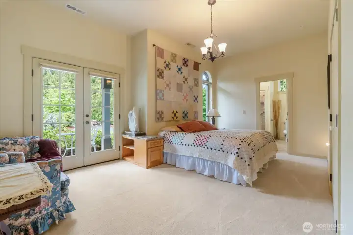 One of the guest bedrooms. Small veranda off to the left to enjoy morning coffee. Each guest room has custom tile step in showers and heated bathroom floors.