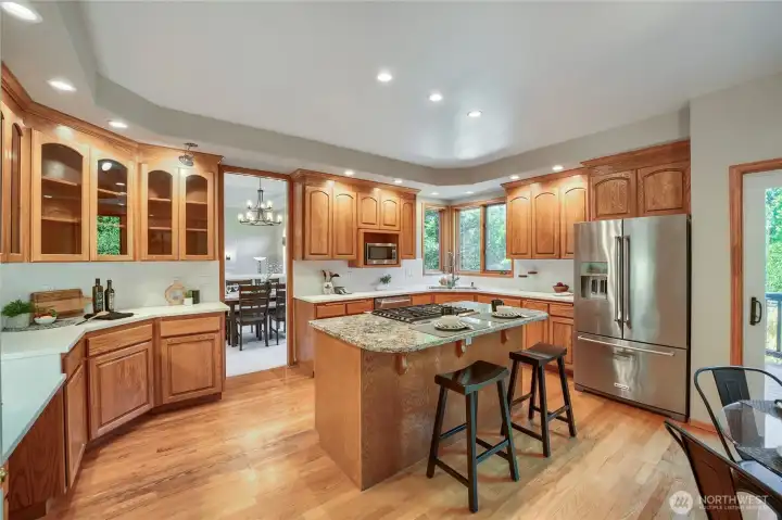 Solid oak and glass cabinets with large island and eat in kitchen.
