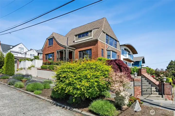 Perched on a prominent corner, atop West Seattle's historic North Admiral residential plateau, this distinguished 1927 brick residence is framed by sweeping views of Elliott Bay, the Seattle skyline, the Cascade Mountains, and Mount Rainier.