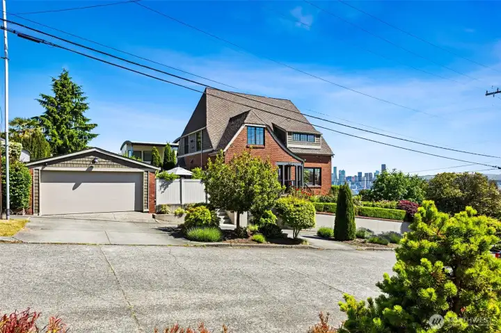 An attached carriage garage and detached two-car garage provide EV charging and workshop flexibility.