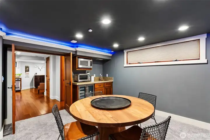 Wet bar features side-by-side bar refrigerator, microwave, and sink.