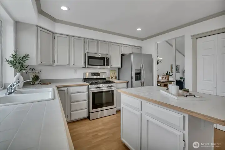 Gas cook top, lots of cabinets and a pantry on the right.