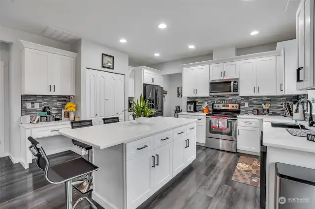 Crisp white cabinetry and a spacious pantry provide abundant storage space.