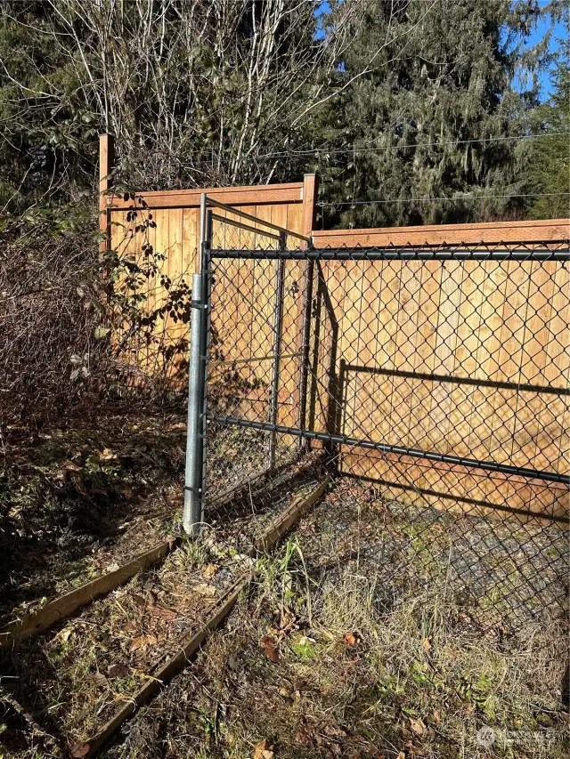 Side entrance gate for utility access. This gate remains unlocked, but leads to 2 other locked gates, 1 for Ziply & PUD, and the other for the owner.