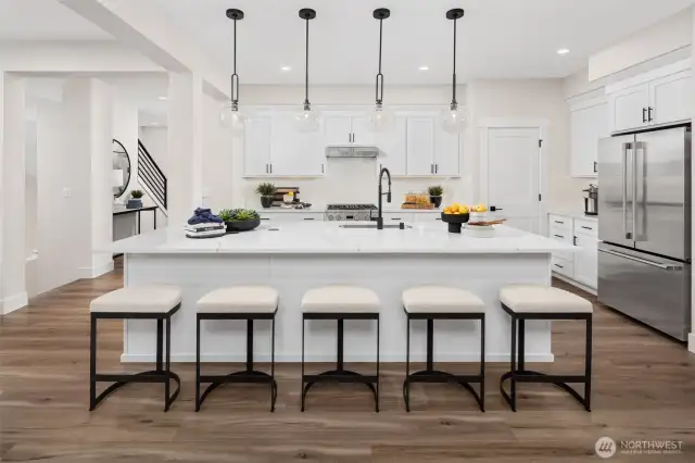 Chef's dream kitchen boosts generous island. Photo of decorated model home.