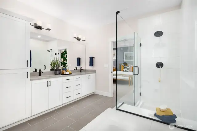 Luxurious primary bath highlighted by dual vanity, large shower, soaking tub, separate toilet closet and ample storage-photo of decorated model home.