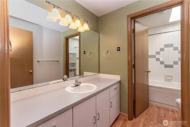 Common bathroom with door leading to stool, jetted tub and shower.