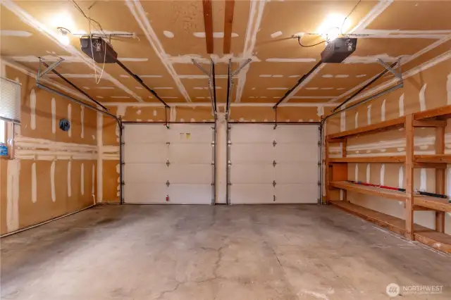 Double car garage with window and built-in wood shelving.