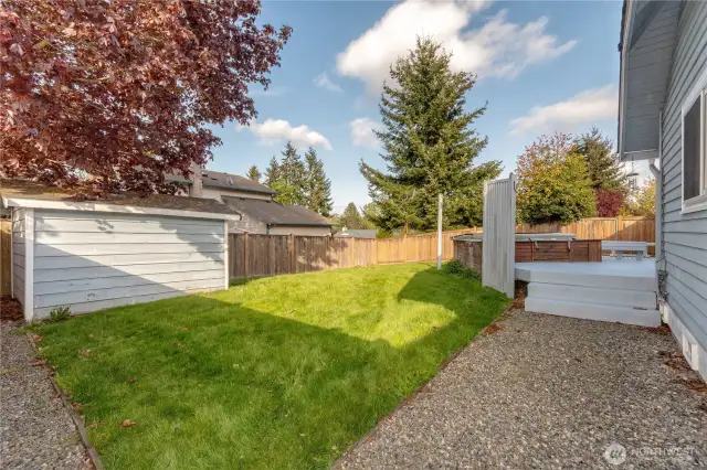 Backyard shed with gravel walkway to shed and deck.