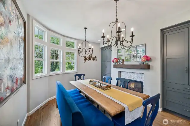 The dining space has a double sided fireplace and two large storage cabinets.